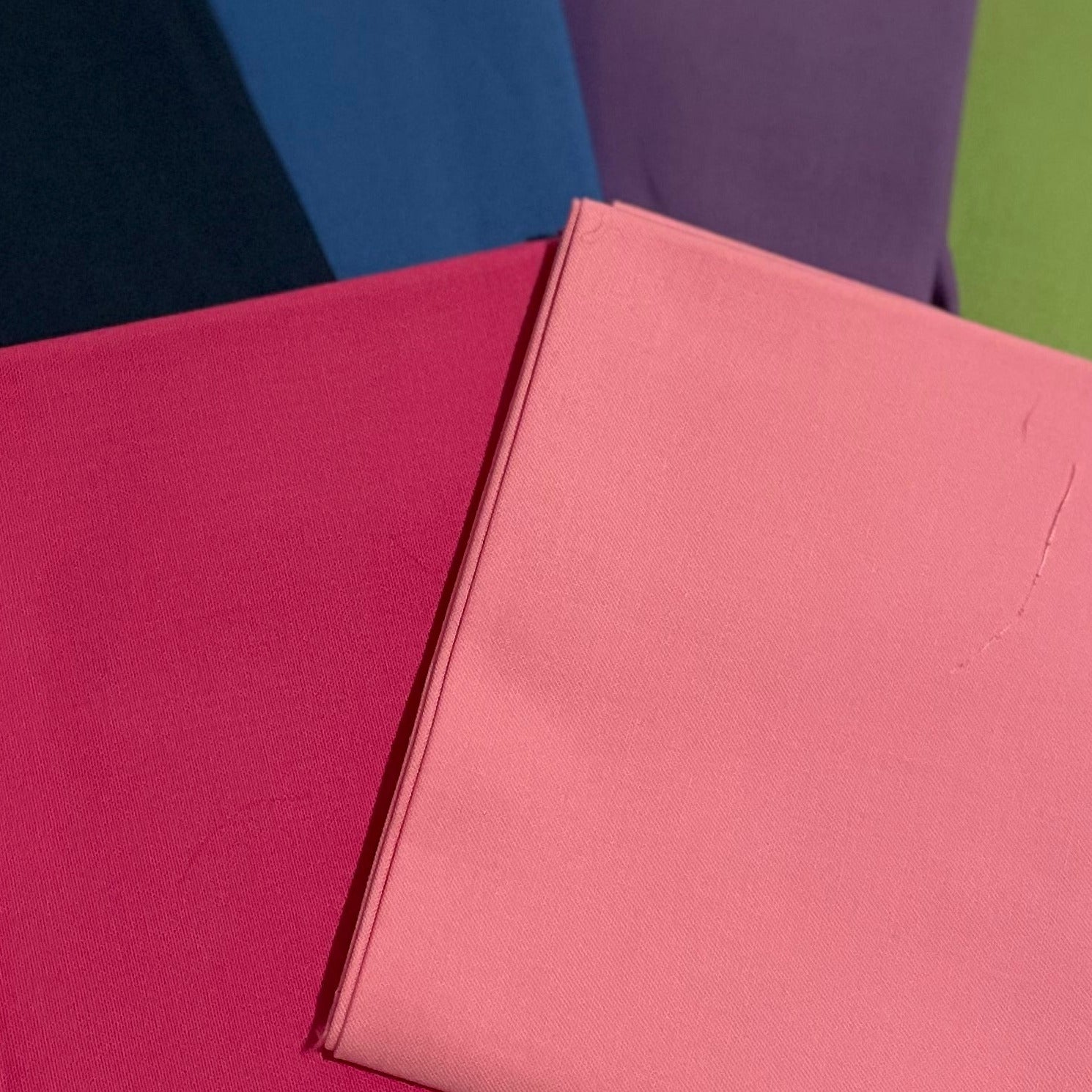 Five colorful books stacked on a beige surface