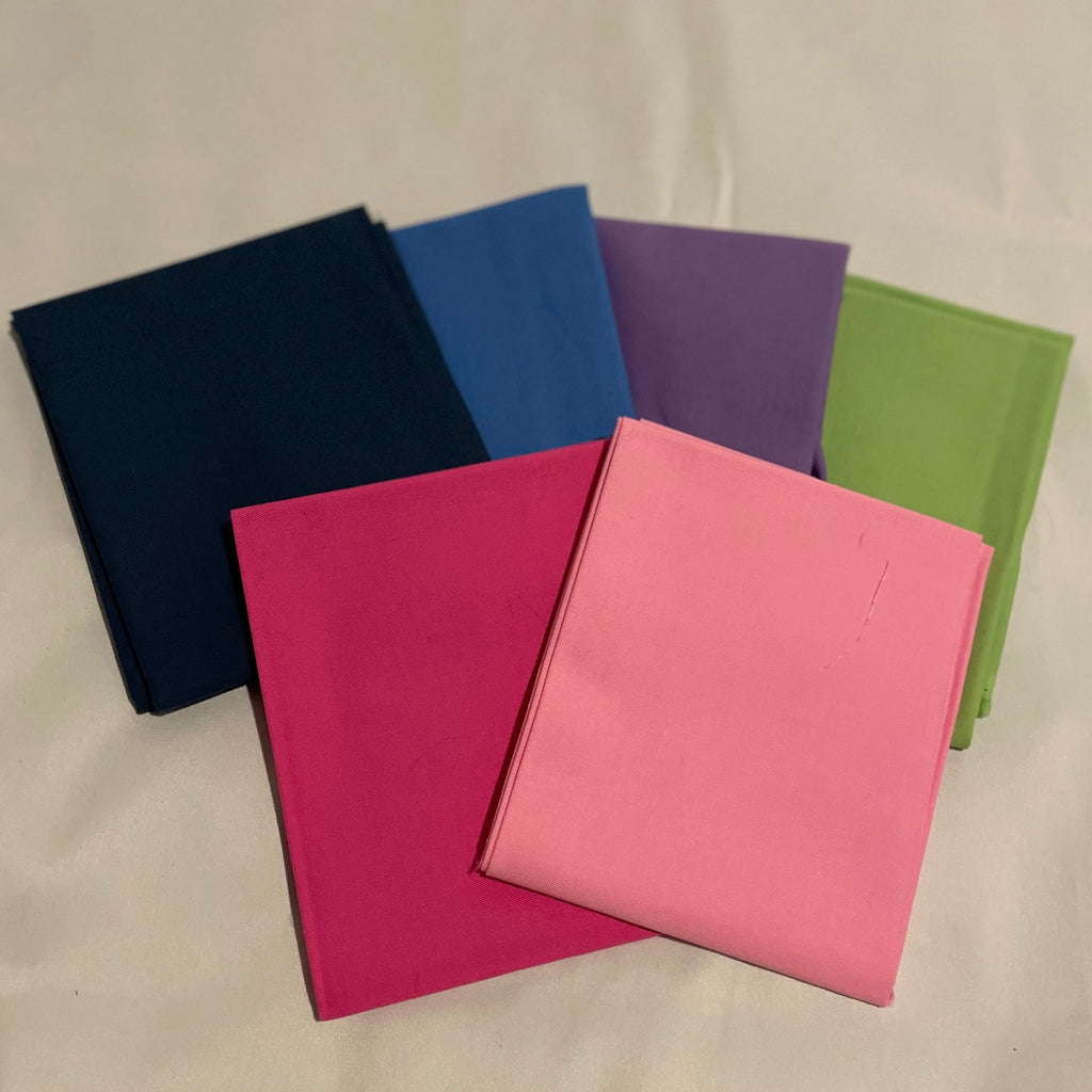 Five colorful notebooks arranged on a beige surface.