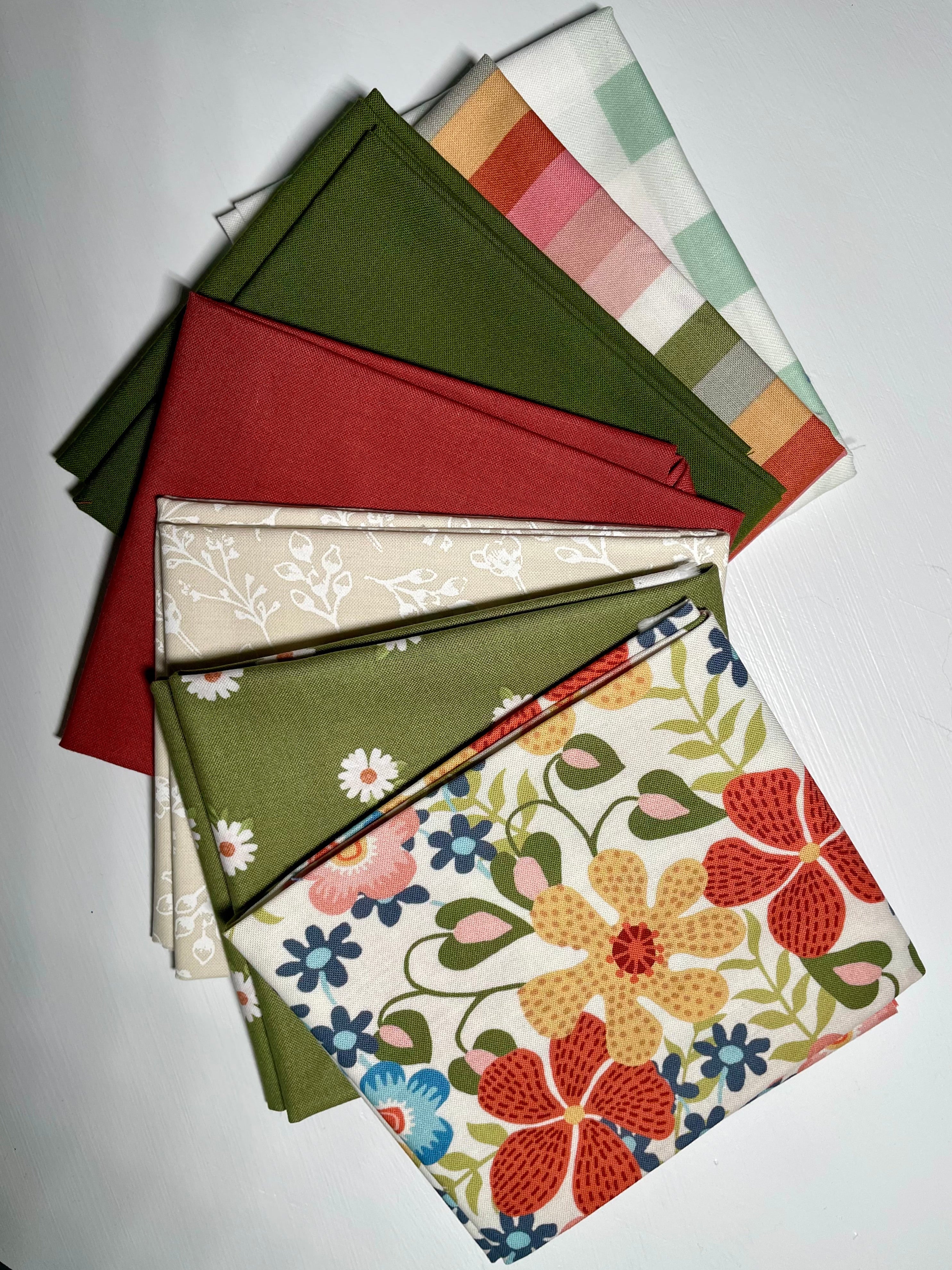 Colorful late summer fabric bundle on white table