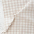 Close-up of beige and white checkered fabric with a visible brand name.
